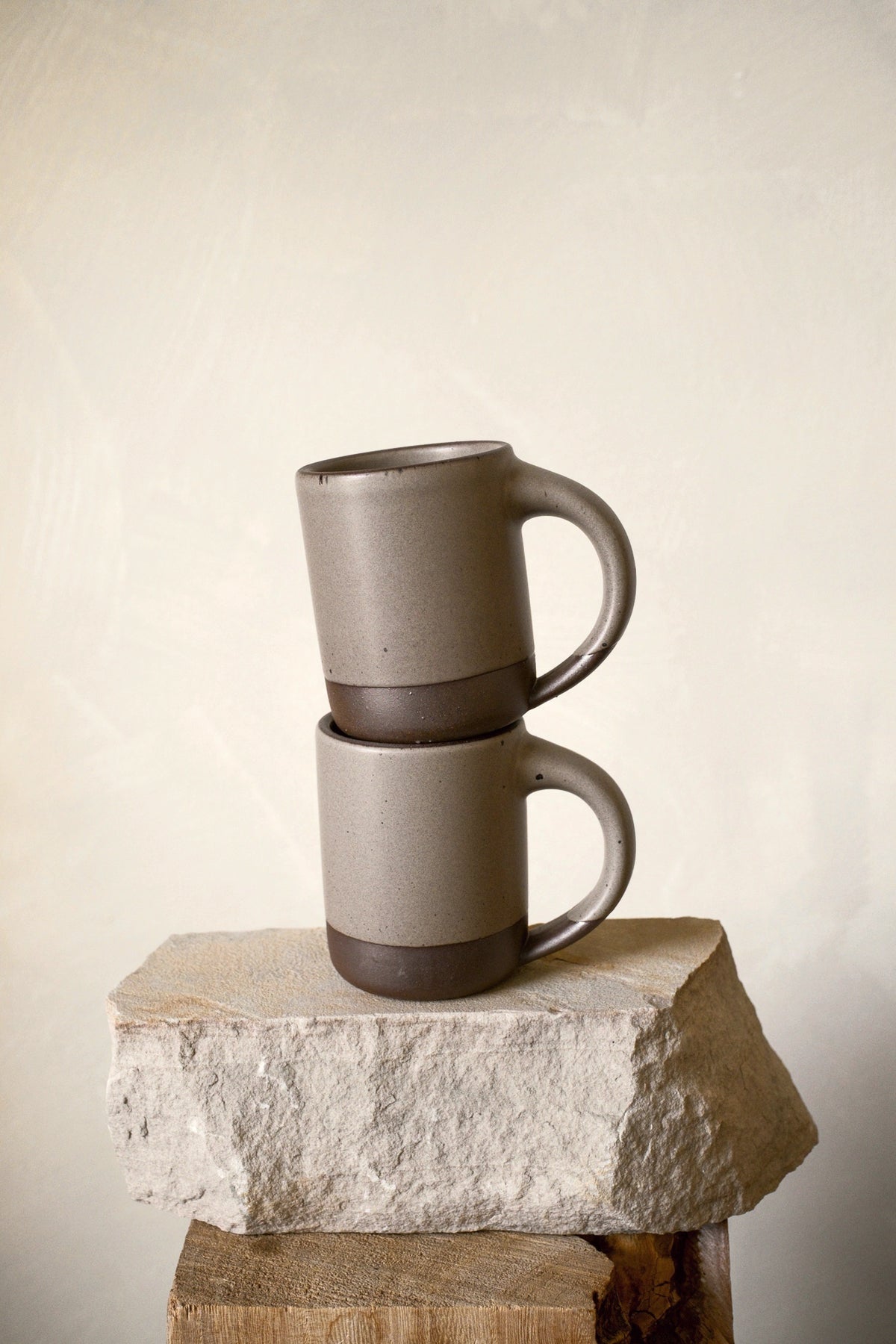 Two East Fork Mugs in Morel stacked on stone